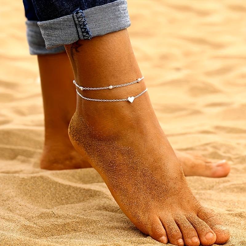 Delicati Charms enkelband met romantische dubbelgelaagde ketting, voorzien van een hartbedel en verfijnde kralen, perfect voor een elegante en subtiele look.